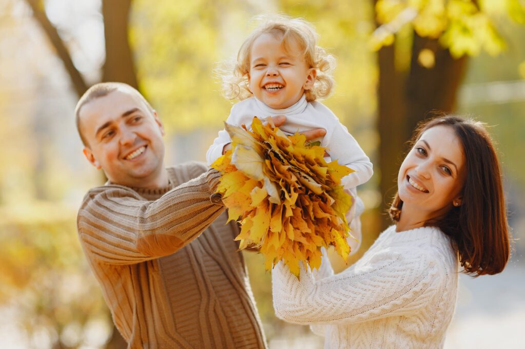 joyful family playing in autumn forest